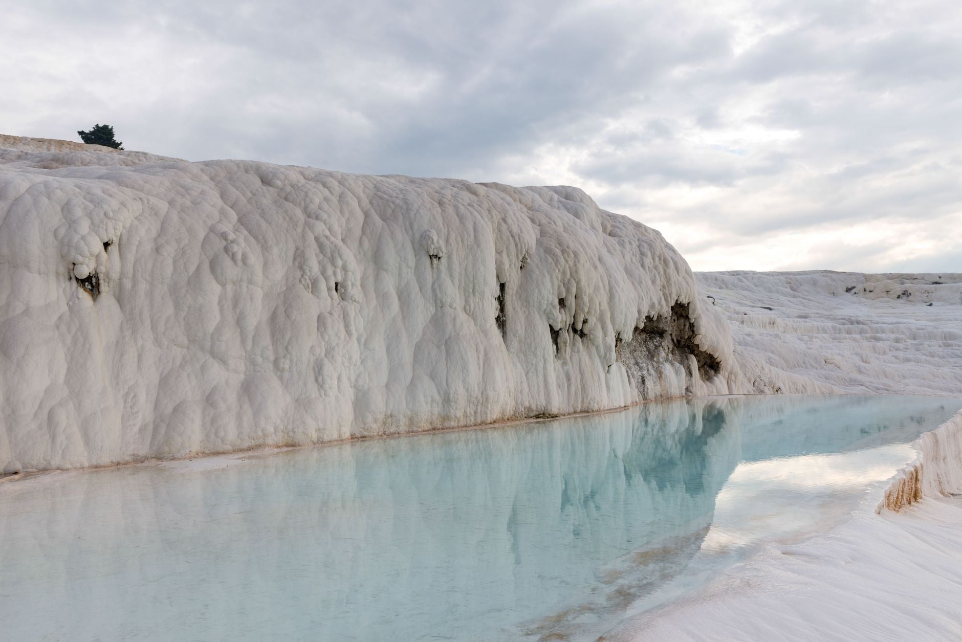 Mineral rich thermal spring water pooling over pale travertine terraces