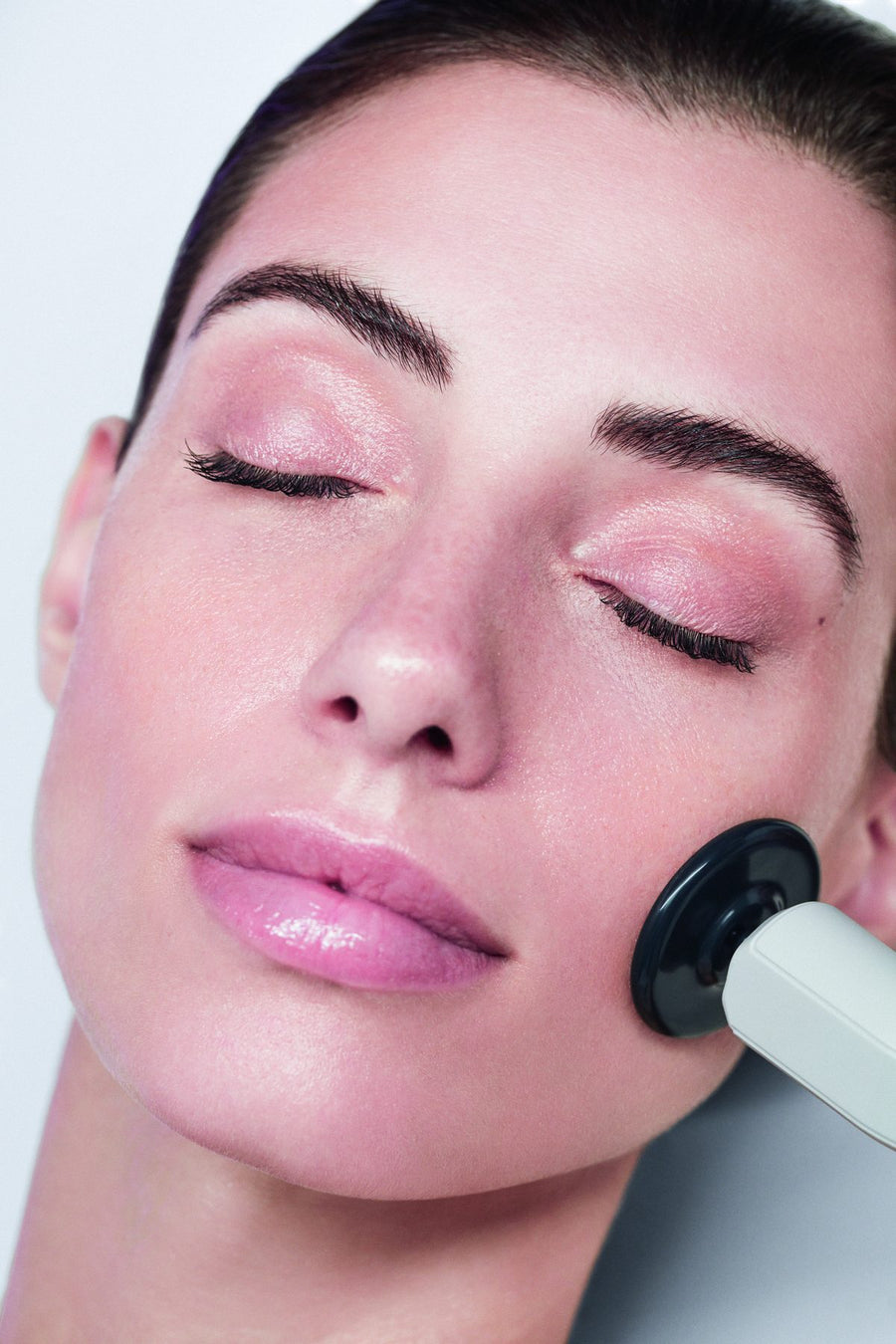 The MEGAN handpiece resting against a client's cheek